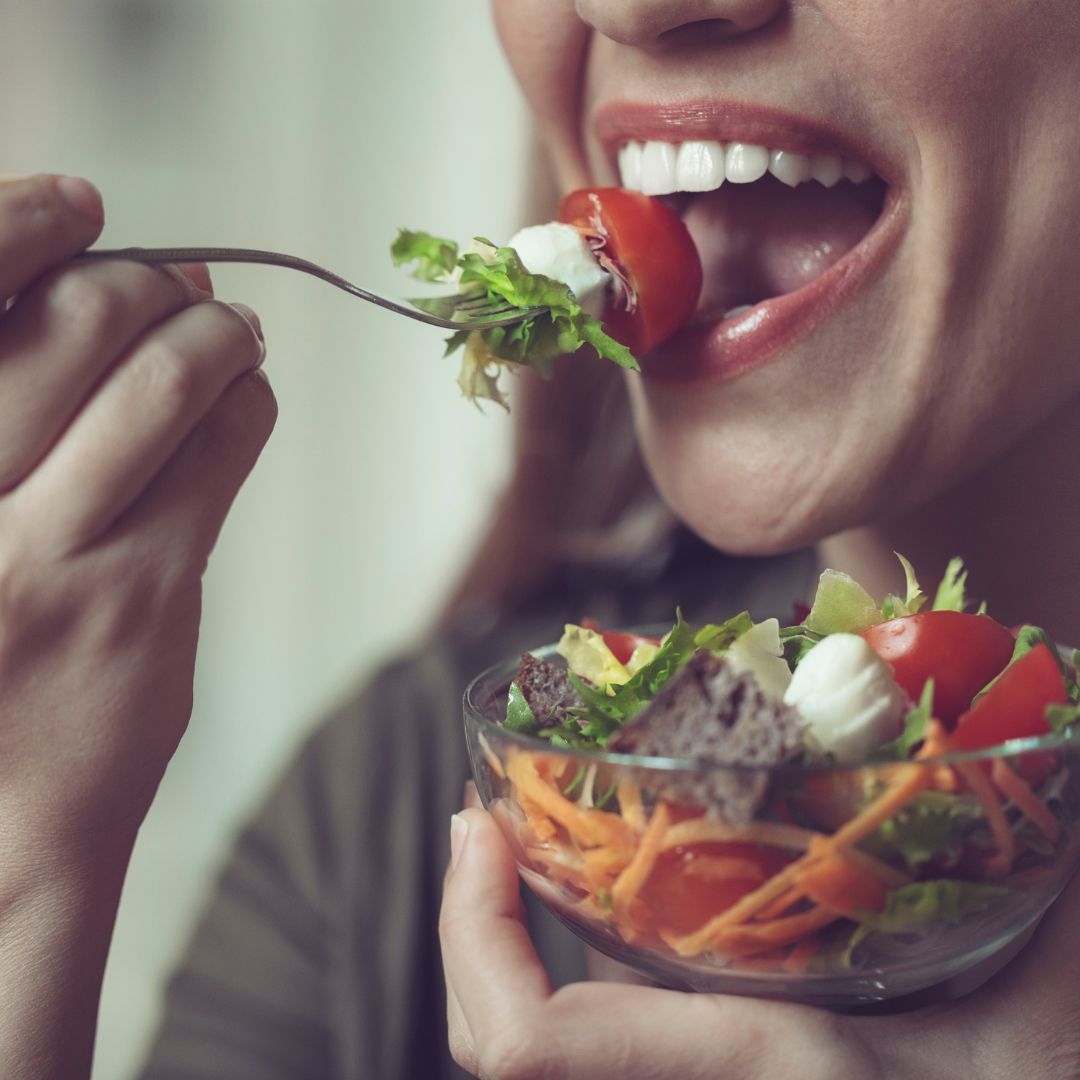 smiling woman eating salad