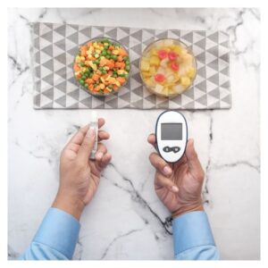 a man checking his glucose levels with a health snack in front of him