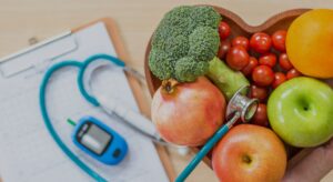 a diabetes monitor on a clipboard with healthy food in a bowl