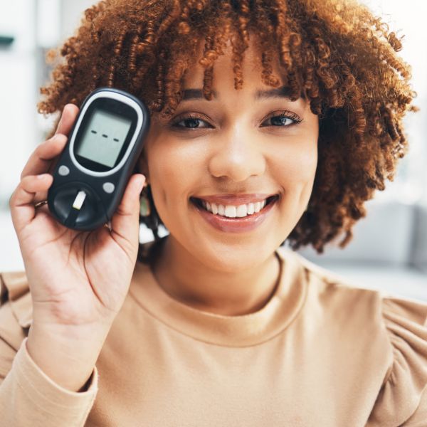 woman smiling with glucose monitor