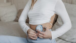 Woman placing an insulin pump on her stomach