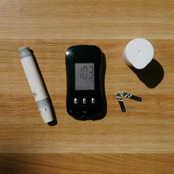 Glucose monitors, needle, and strips on a table.